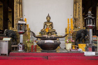 Buddha statue against wall in ancient temple