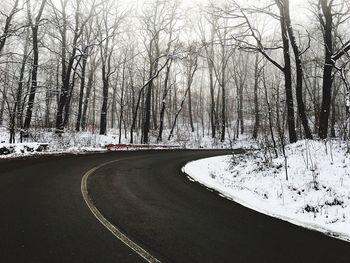 Road amidst bare trees during winter