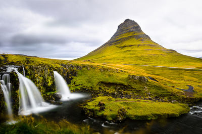 Scenic view of waterfall against sky