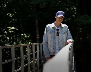 Full length of teenage girl standing against railing