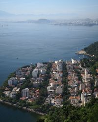 High angle view of cityscape by sea against sky