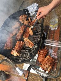 High angle view of man preparing food on barbecue grill