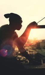Close-up of silhouette man against sunset sky