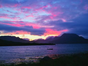 Scenic view of mountains against cloudy sky at sunset