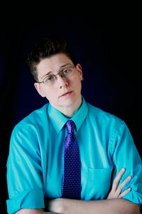 Portrait of young man against black background