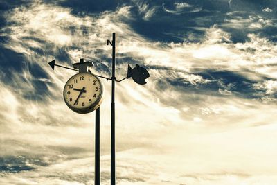 Low angle view of weather vane against sky