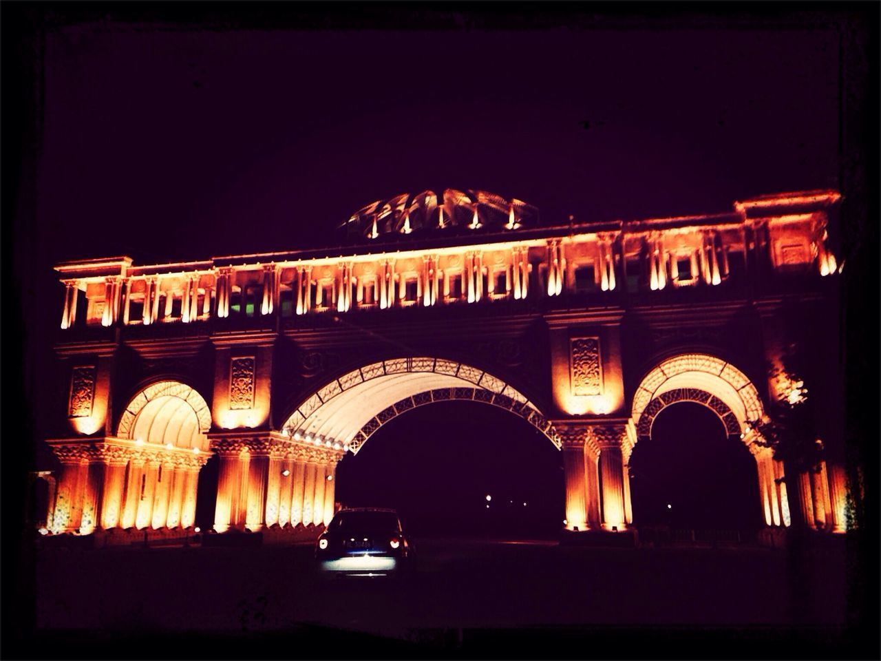 night, illuminated, architecture, built structure, building exterior, arch, transfer print, low angle view, dark, auto post production filter, facade, copy space, clear sky, history, no people, outdoors, building, window, sky, architectural column