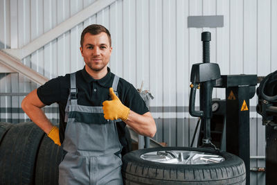 Portrait of young man standing in factory