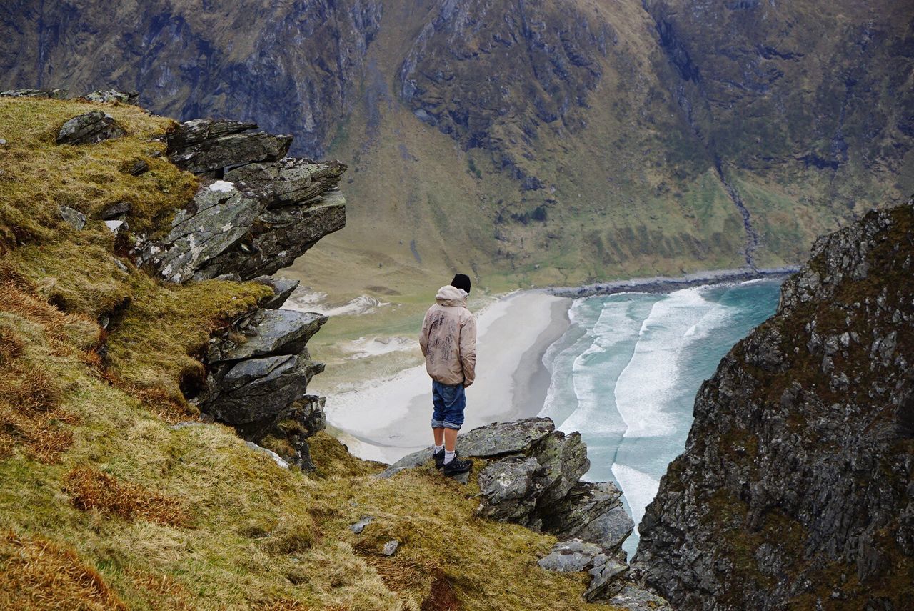 water, mountain, tranquility, lifestyles, tranquil scene, leisure activity, rock - object, beauty in nature, scenics, nature, rear view, full length, standing, rock formation, idyllic, men, non-urban scene, vacations