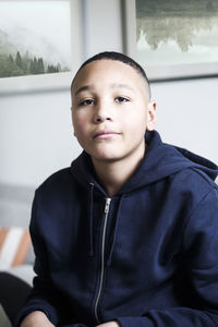 Portrait of teenage boy wearing hooded jacket at home