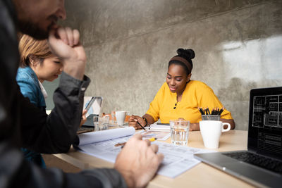 Architects discussing blueprint on table