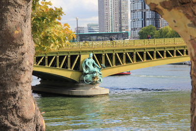 Bridge over river in city against sky