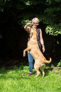 Full length of man with dog on grass