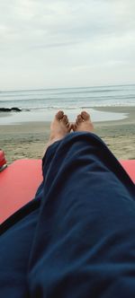 Low section of man relaxing on beach