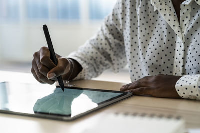 Female hand writing on digital tablet in living room at home