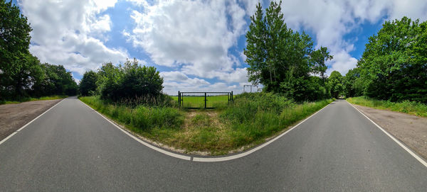 Beautiful high resolution panorama of a northern european country road with fields and green grass.
