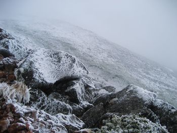 Scenic view of sea and snowcapped mountains against sky