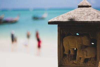 Close-up of sculpture at beach against sky