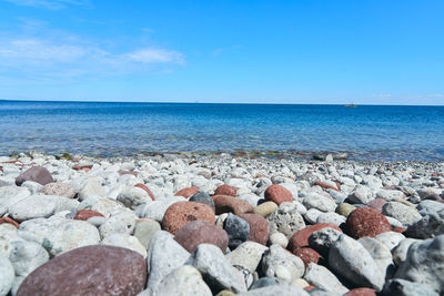 Rocks on beach against blue sky