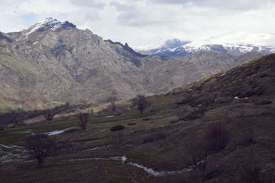 Scenic view of mountains against cloudy sky
