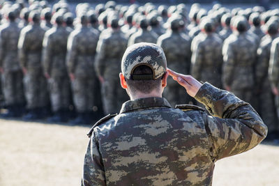 Rear view of man with arms outstretched standing outdoors