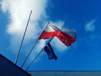 Low angle view of flag against blue sky