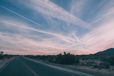 Road by landscape against sky