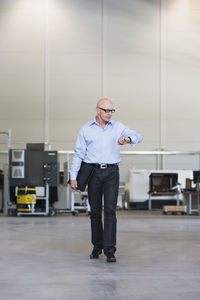 Man walking on factory shop floor checking the time