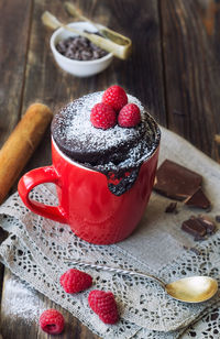 Fresh homemade chocolate cake in mug on rustic wooden background. cooked in microwave.