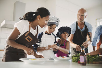 Family preparing asian food at table in kitchen