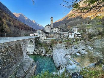 Arch bridge over river against buildings