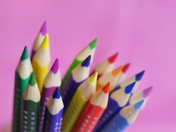 Close-up of multi colored pencils against purple background