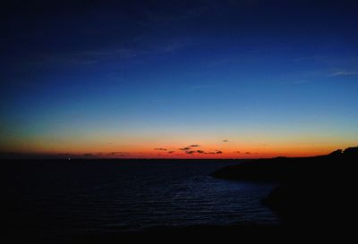 Scenic view of sea against clear sky at sunset