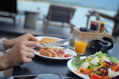 Midsection of person having food on table