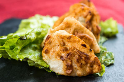 Close-up of snacks with lettuce on stone plate