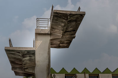 Low angle view of sculpture on roof of building against sky