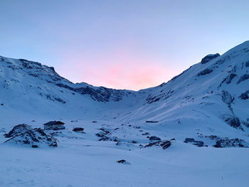 Scenic view of snow covered mountains against sky during sunset