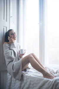 Woman sitting on table at home