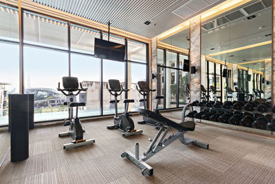 Modern gym room and equipment with city and sky view