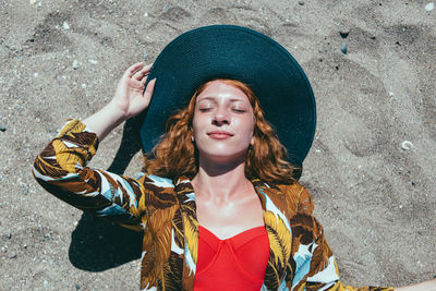 Woman in hat lying on beach