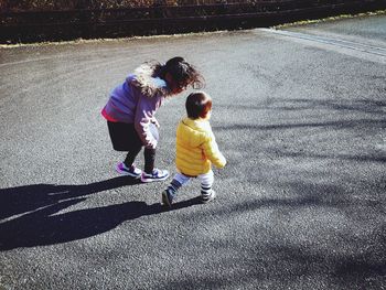 High angle view of siblings walking on road