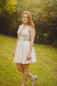 Portrait of young woman walking against trees