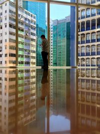 Reflection of man on glass window in city