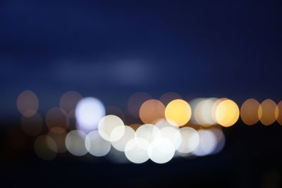 Defocused lights against sky at night