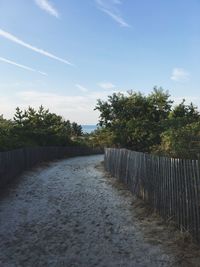 Empty road against cloudy sky