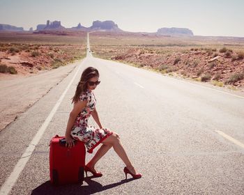 Rear view of woman walking on road