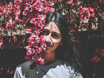 Portrait of smiling woman with red flowers