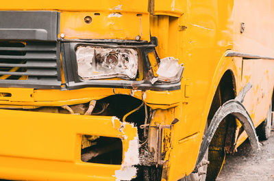 Accident on the road in city with shuttle bus. damaged yellow bus on sidewalk. damaged headlight