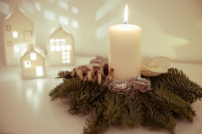 Close-up of illuminated candles on table at home