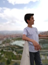 Side view of man looking away against sky